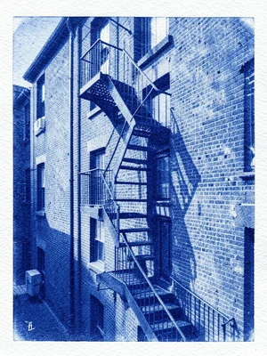A fire escape zigzagging down the side of a brick apartment building