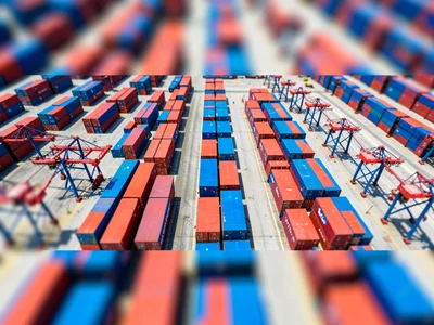 Aerial tilt-shift photograph of a container port at midday from drone height, ro