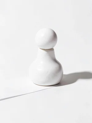Rotund chunky clay chess piece pawn in primary white with stubby round head and