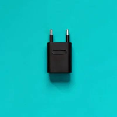 Catalog hero of a single charging connector silhouette on a saturated teal backd
