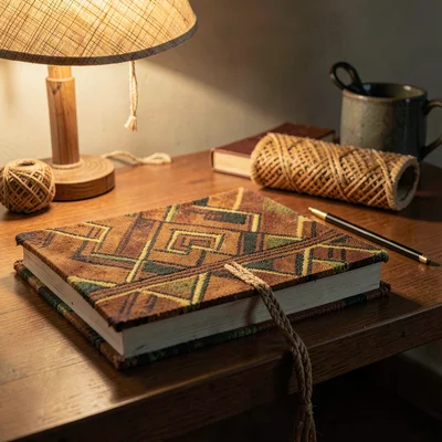 Warm tapa cloth browns and geometric pattern rhythm, Stacked books on a desk wit