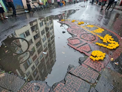 Monsoon puddle with kolam reflection
