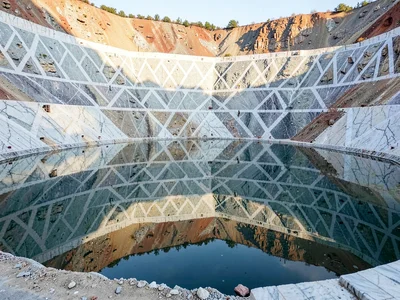 Quarry pool perfectly reflecting cut walls above