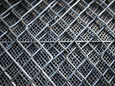 Two layers of chain link overlapping at different angles, moiré interference pat