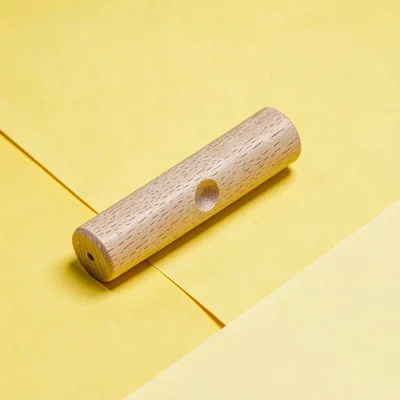 single hand-pressed wood-block-set printing roller resting at angle on a saturat