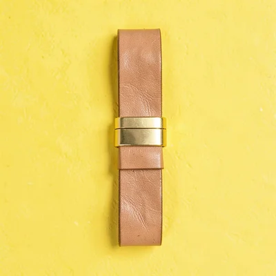 single chunky leather notebook strap-and-loop set straight-on against a saturate