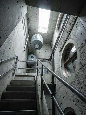 Concrete stairwell inside the core tower — industrial railing, exposed aggregate