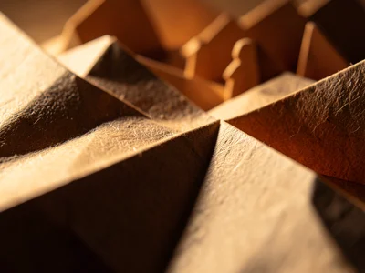 Origami nativity scene, small paper figures, warm lighting behind