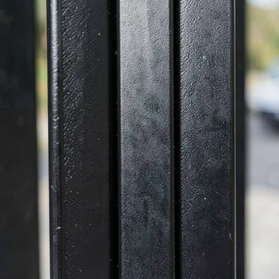 Tight crop of black aluminum fence pickets with a powder-coat satin finish and a