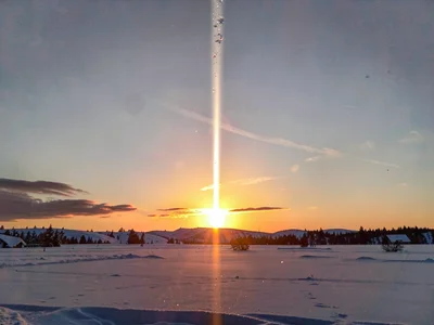 Light pillar extending vertically from setting sun
