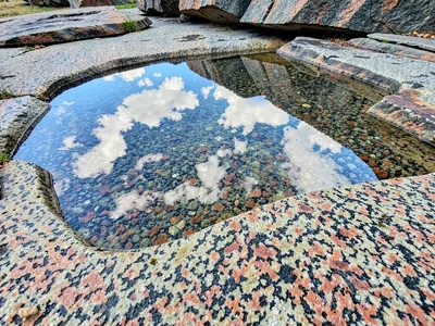 Surface pool reflecting sky on granite