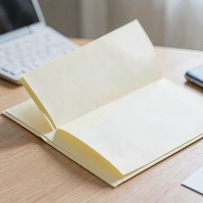 Macro of a manila folder open on a desk with blank cream pages inside, soft dayl