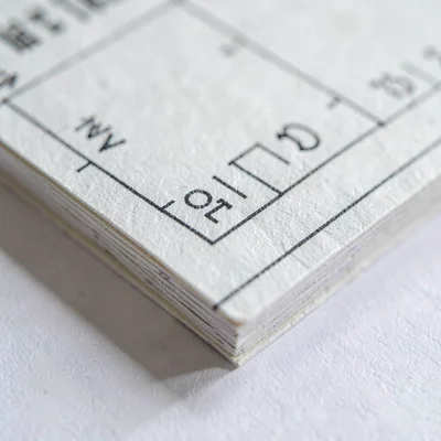 Paper-texture macro of a stack of pencilled measurement cards