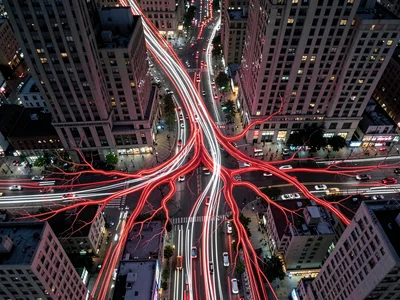 A 30-second exposure of city traffic from above, red and white light trails form