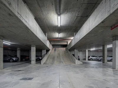 A multi-story car park interior — exposed ramp structure, raw board-formed concr
