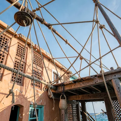 Coastal architecture photograph with Swahili influences, Dhow rigging ropes in c