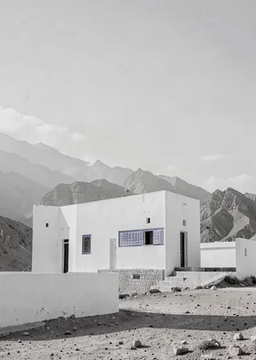 Extreme minimalist restraint of Muscat, Oman, fort tower against mountains, mono
