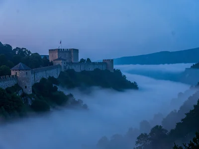 Fortress walls on hill above perfect fog sea