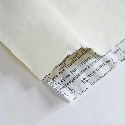 Inside spread of a torn paper edge revealing a printed fragment of code-like pat