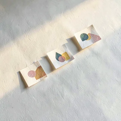 Trio of small abstract paper printouts arranged in a stepped staircase across a 