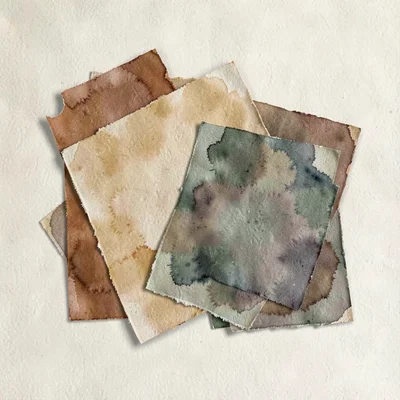 Cozy flatlay of overlapping warm paper sheets in muted tones on a soft cream sur