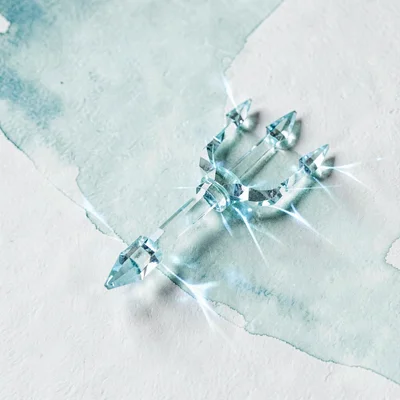Cut aquamarine lowpoly trident with three sharp faceted prongs throwing cool blu