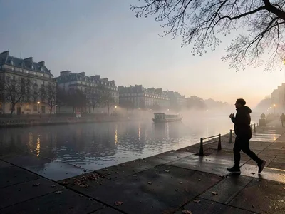 Morning jogger silhouette on foggy quay
