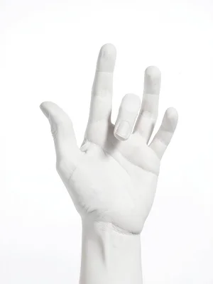 White plaster hand reaching upward on white seamless, soft shadows defining fing