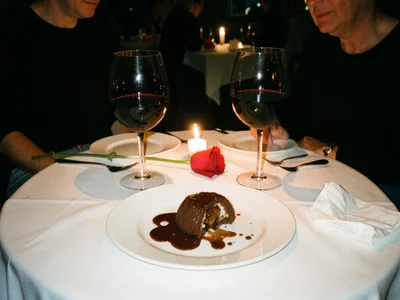 A restaurant table for two after dessert, a half-eaten chocolate fondant with a 