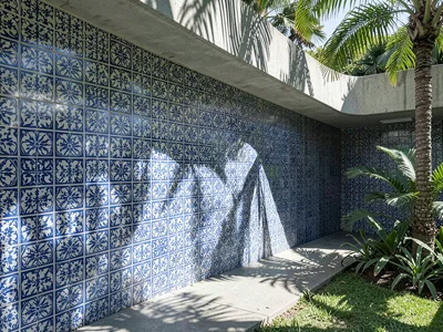 Garden wall entirely covered in blue-and-white azulejo tiles, cast shadow of pal