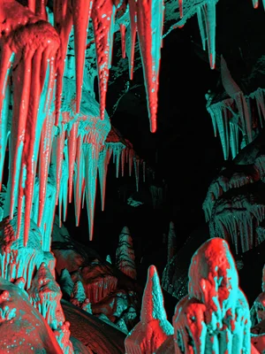 A crystal cave with stalactites in the foreground fringing strongly in red and c