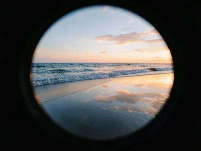 Ocean horizon through pinhole, exposure length letting waves smooth into mercury