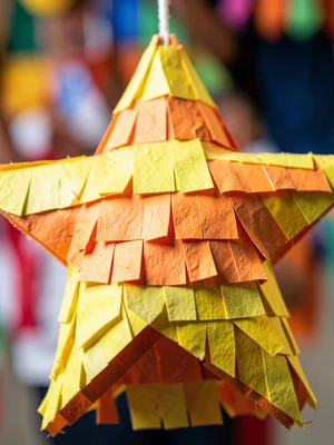 A star piñata in yellow and orange, macro surface showing individual paper strip
