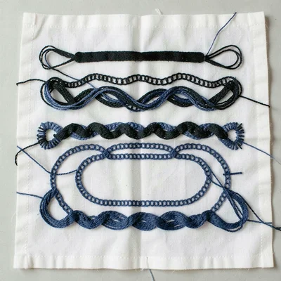 Thread color comparison — skeins of black and indigo blue Ainu embroidery thread