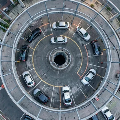 Parking garage spiral seen from directly above, cars making a fibonacci of metal