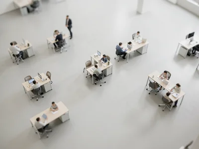 Office floor from above, tilt-shift, tiny workers at tiny desks