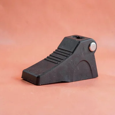 Catalog shot of a wheel chock on a coral backdrop, soft wraparound light