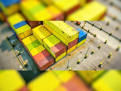Bird-eye tilt-shift view from a harbor crane of stacked shipping containers in s