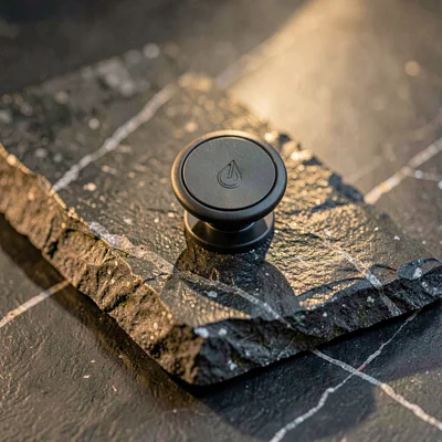 Magnetic phone mount resting on a slab of polished basalt, faint quartz veins ru