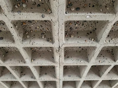 Waffle slab concrete ceiling from below, repeating grid of square coffers creati