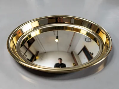 Polished brass tray reflecting room distorted