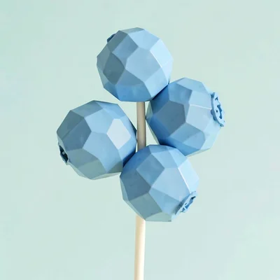 Clustered sky-blue lowpoly blueberries of five chunky orbs on a cream stem, on p
