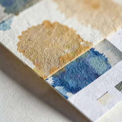 Paper-fold study of a folded color-test card with washes of ultramarine and ochr