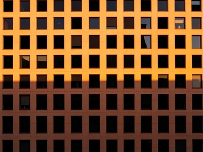 Endless modernist facade of square windows, every fourth window unaccountably bl