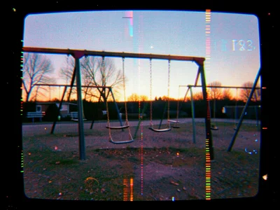 A playground at dusk with swings still moving, image rolling vertically