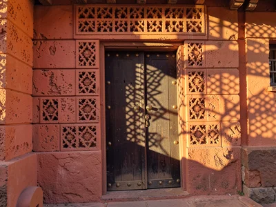 Afternoon sun through mashrabiya lattice in Lamu, Kenya, Swahili door with brass