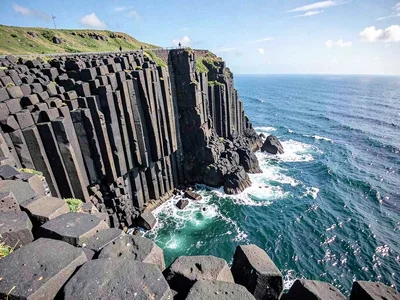 Basalt meeting ocean in columnar cliff