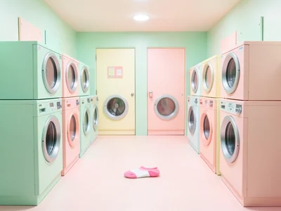 Perfectly symmetrical laundromat in mint green and pale pink, all machines ident