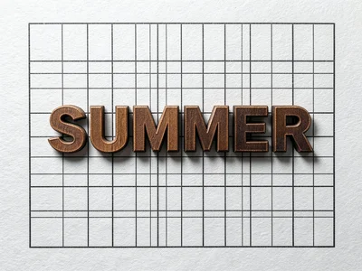Wood type spelling SUMMER arranged in printer's tray, inked, warm tones