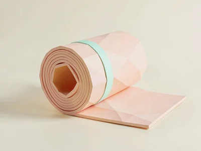 Rolled peach lowpoly yoga mat into a chunky cylinder with a mint strap, on clean